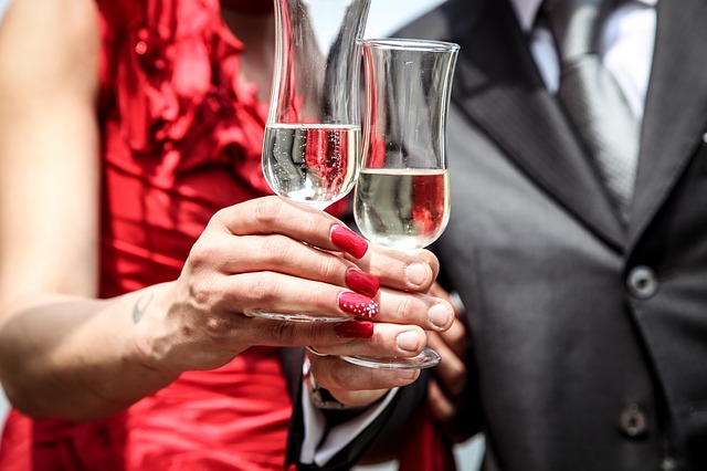 Muž a žena si štrngajú s pohárikmi so šampanským.jpg